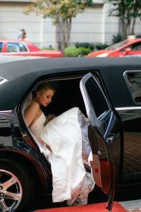 A bride stepping out of a limousine