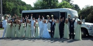 Bridal party cheering in front of a bus